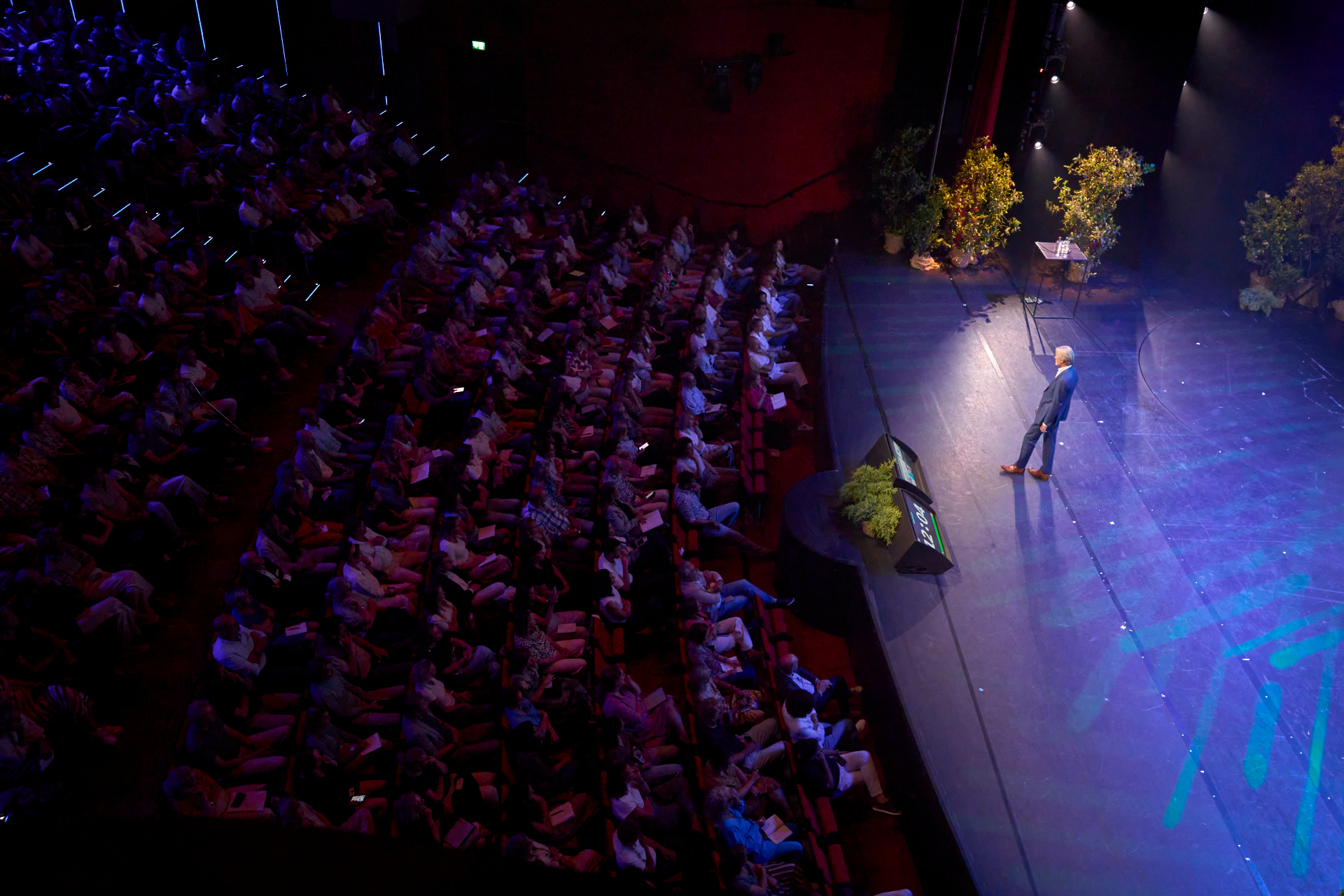 Bob de Wit op het podium voor een volle zaal